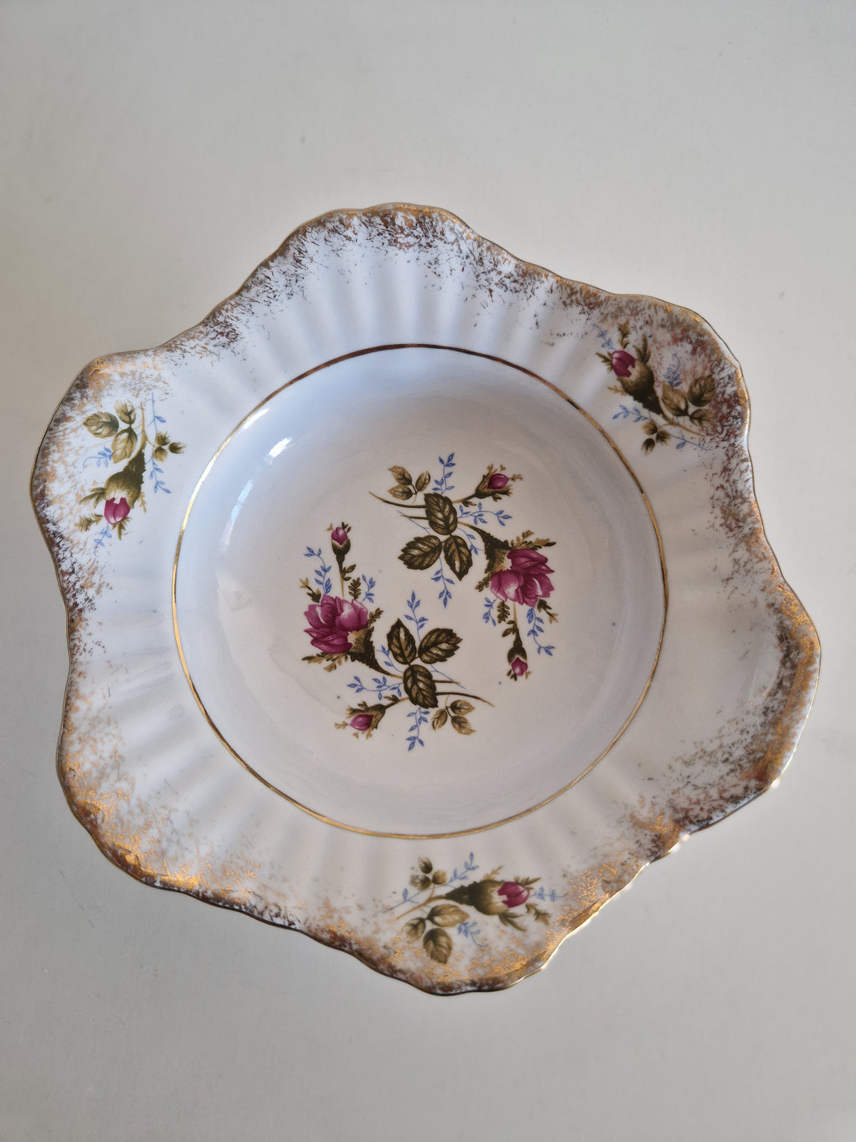 Vintage white porcelain bowl with scalloped gold rim and pink rose floral pattern