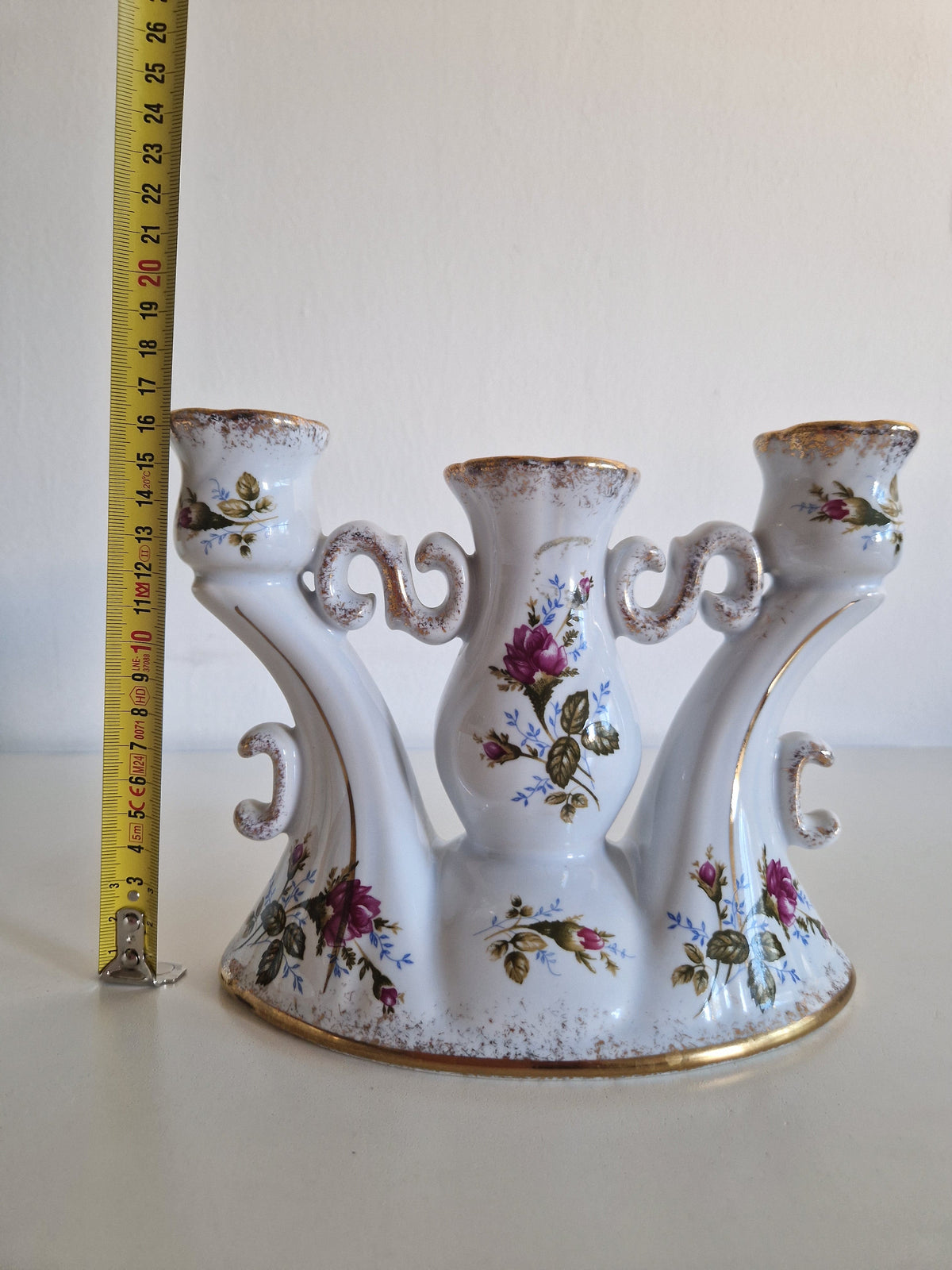 Close-up of gold scroll and rose bouquet detail on candelabra base