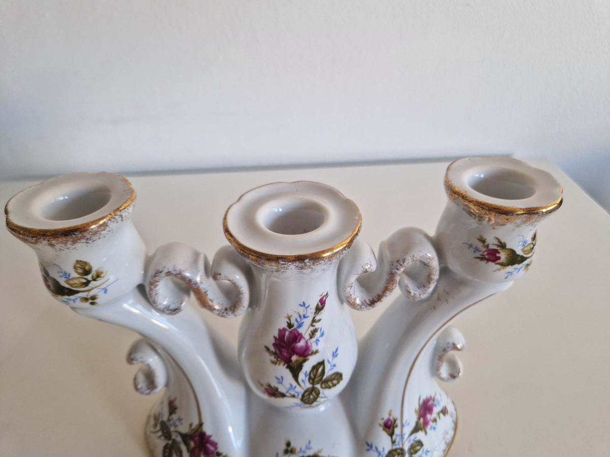 Vintage white porcelain three-arm candelabra with gold trim and pink floral patterns