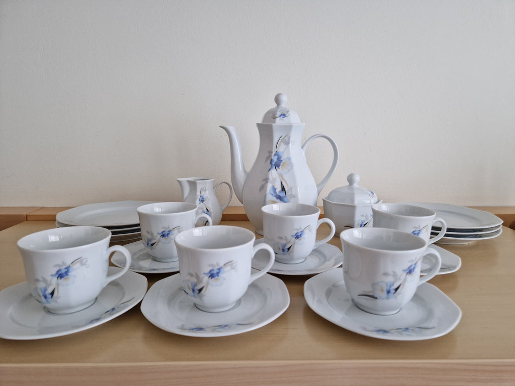 Vintage white porcelain tea set with blue flower patterns including teapot, cups, and saucers