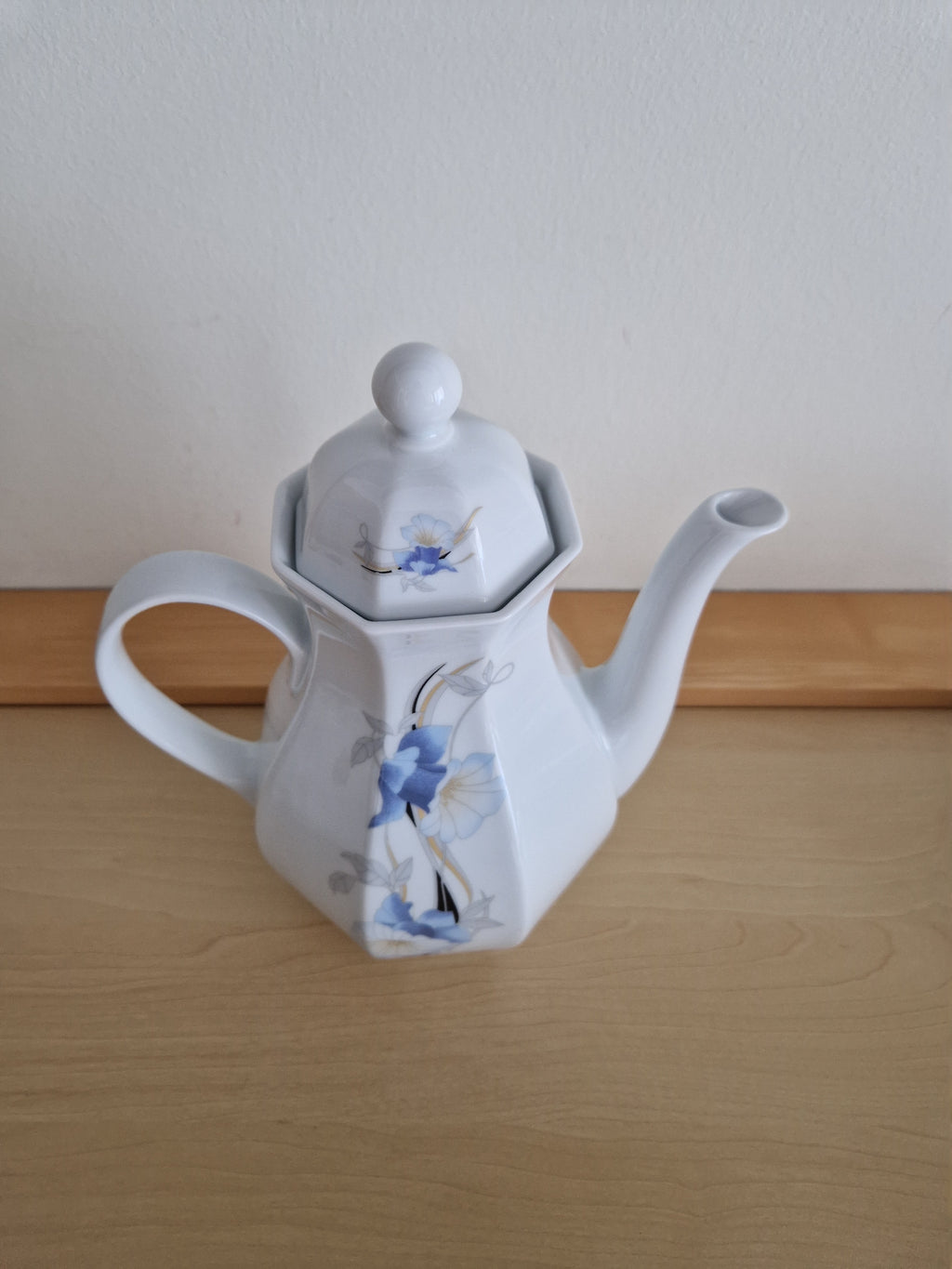Vintage white porcelain teapot with blue floral design and lid