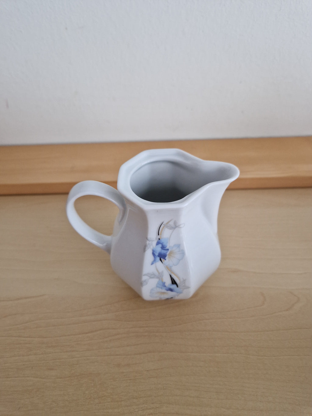 Vintage white porcelain creamer pitcher with delicate blue floral design