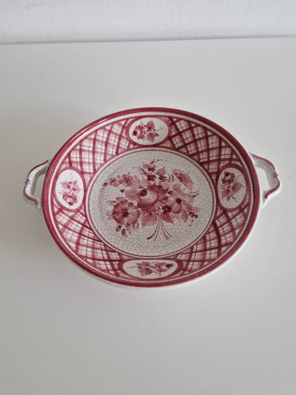 Gmundner Keramik serving bowl angled view showing crackle glaze and floral cartouches