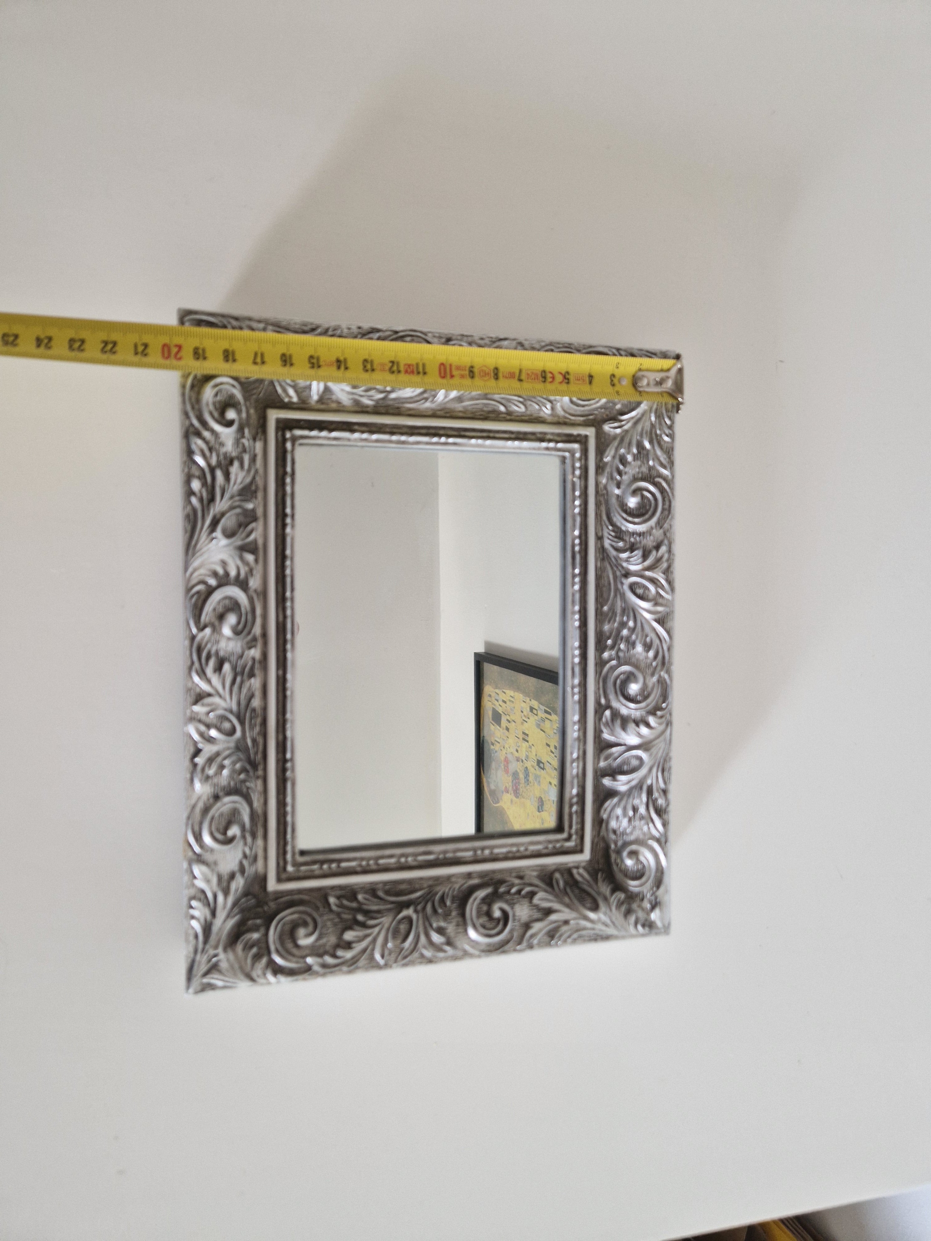 Baroque ornate silver wall mirror with tape measure showing 27cm width, acanthus scroll frame