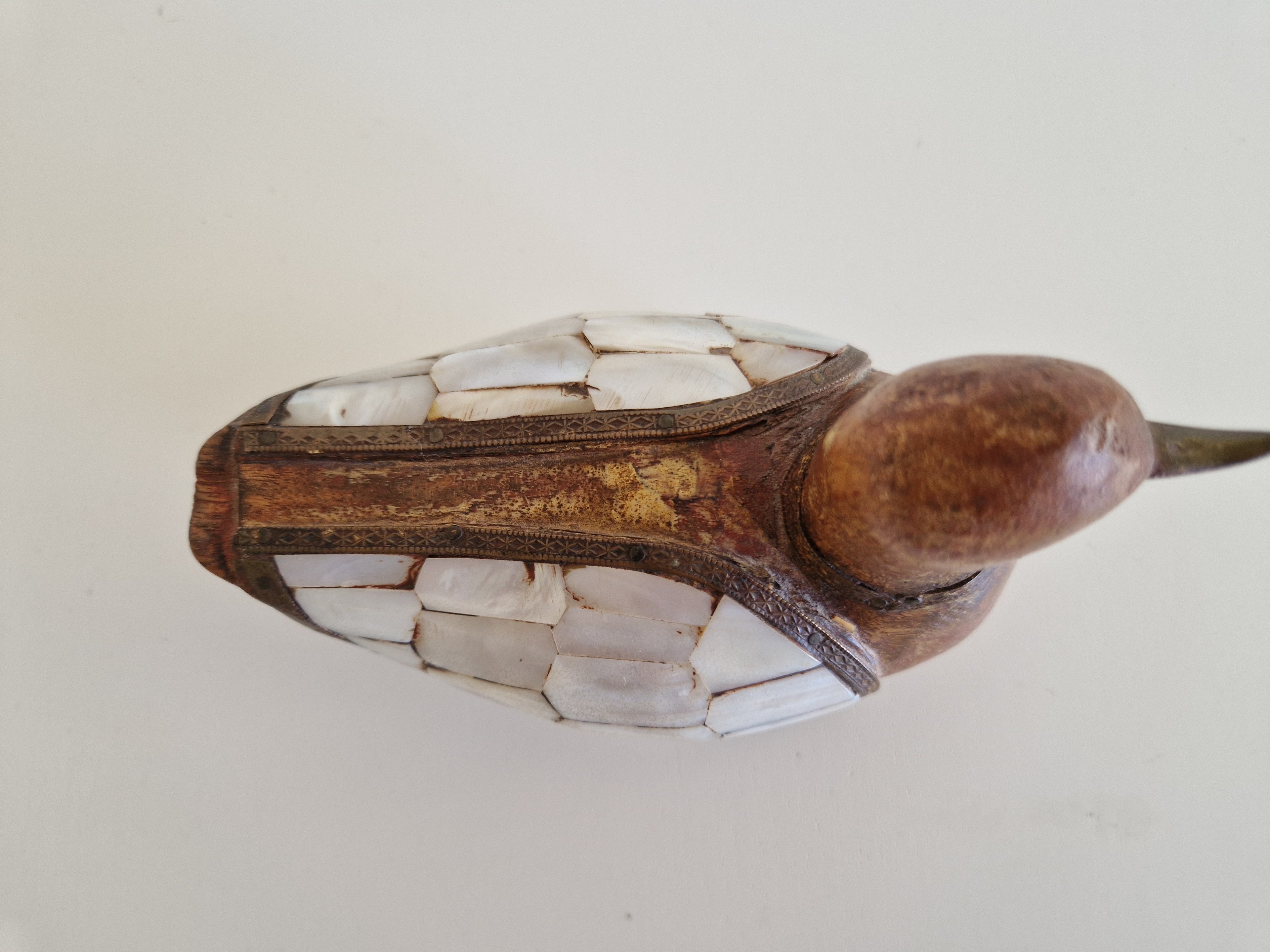 Top-down view of duck figurine showing full bone mosaic inlay pattern and engraved brass border detail
