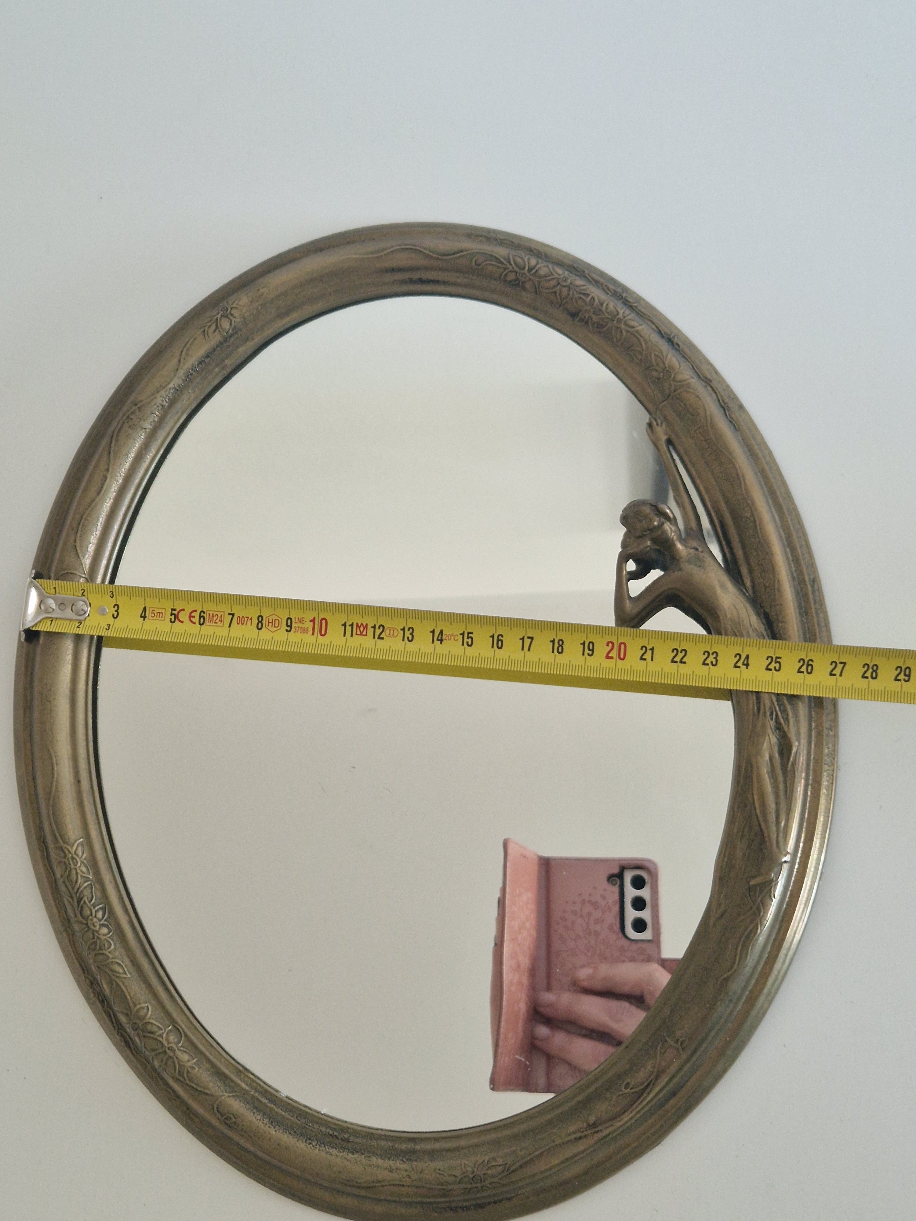 Art Nouveau oval mirror detail showing engraved botanical motifs and aged silver-bronze patina
