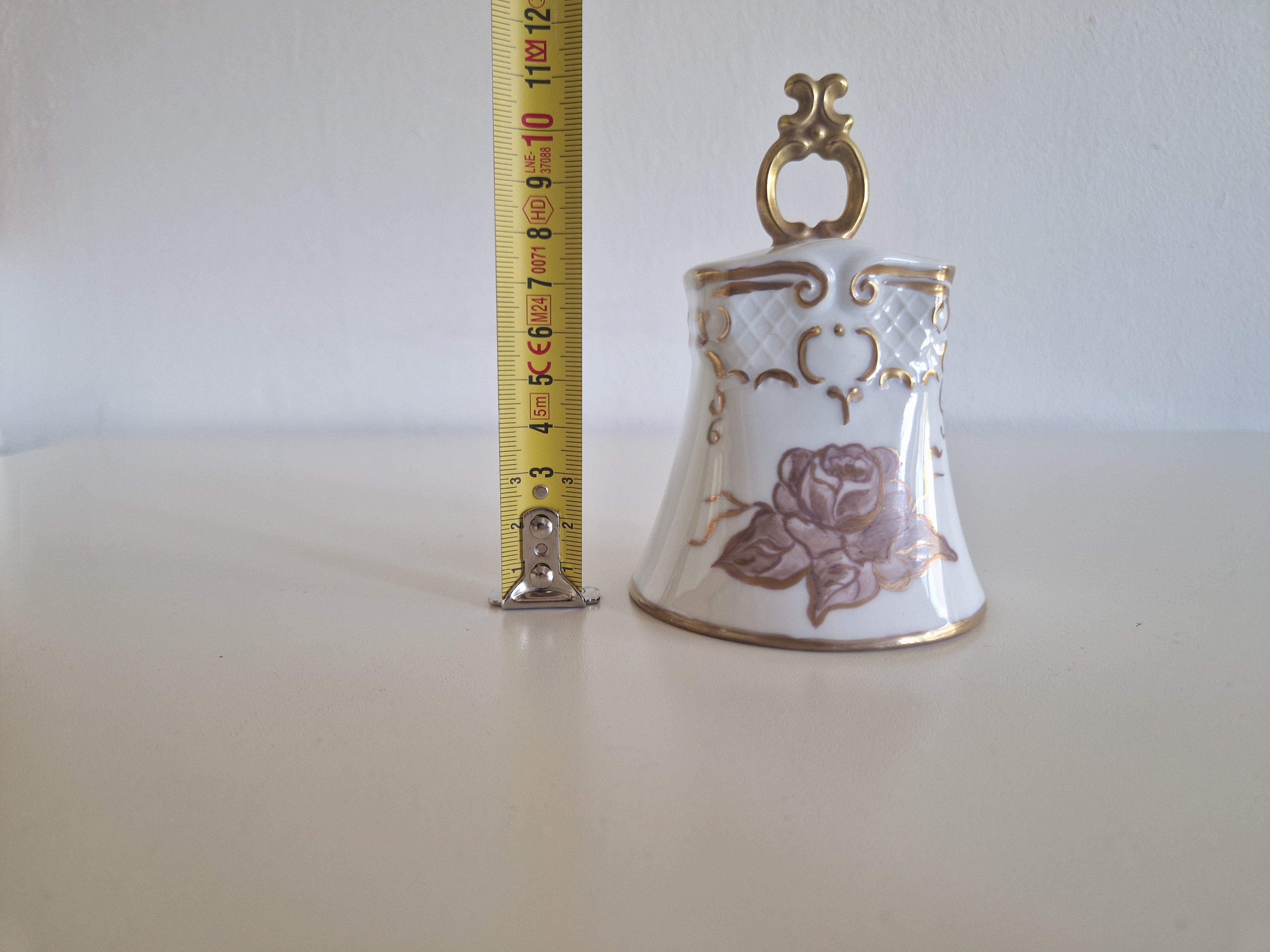 Porcelain bell with tape measure showing approx 9cm height