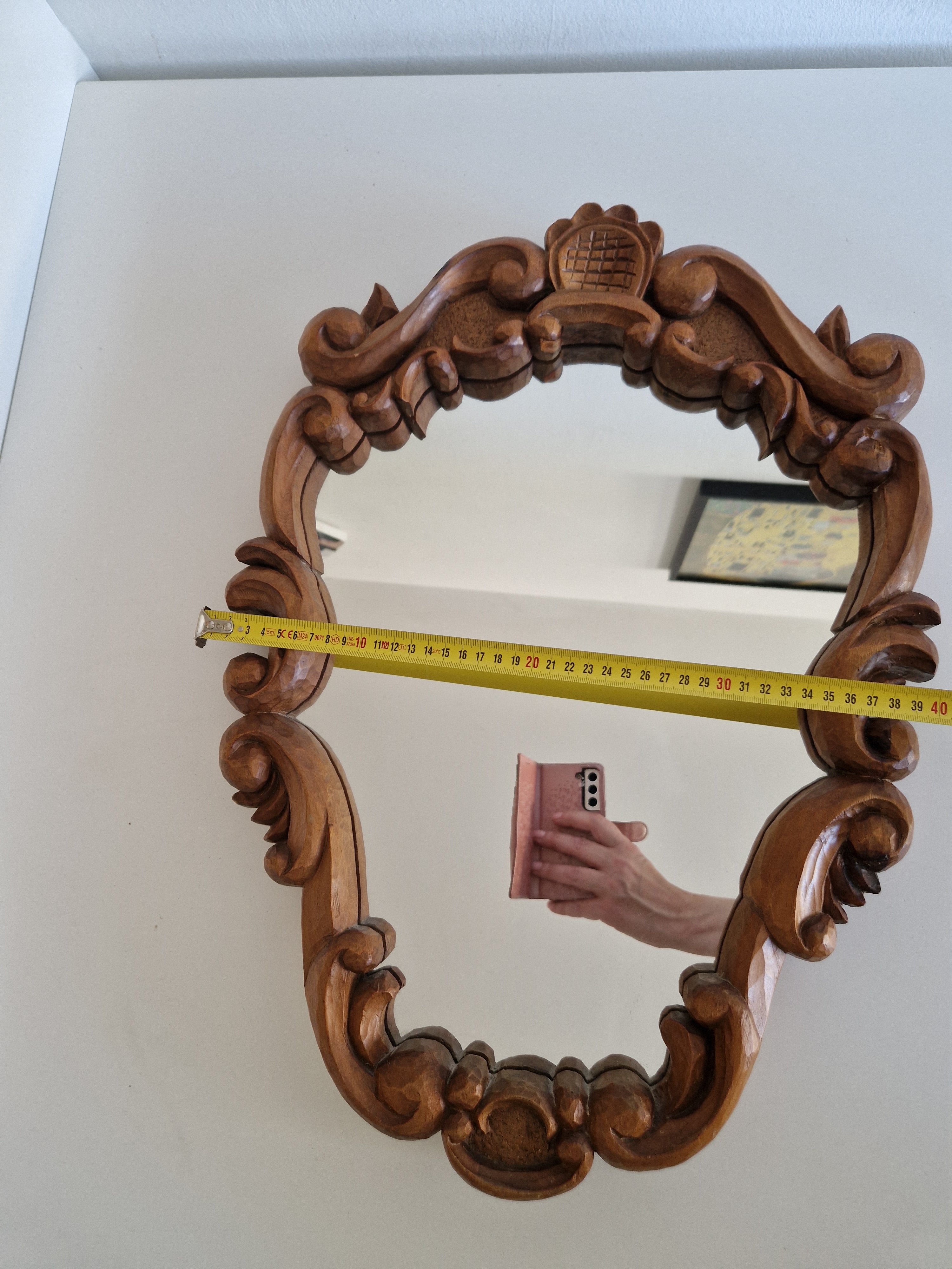 Hand-carved Tyrolean walnut mirror showing cartouche crest and volute base, measured approx. 40 cm wide
