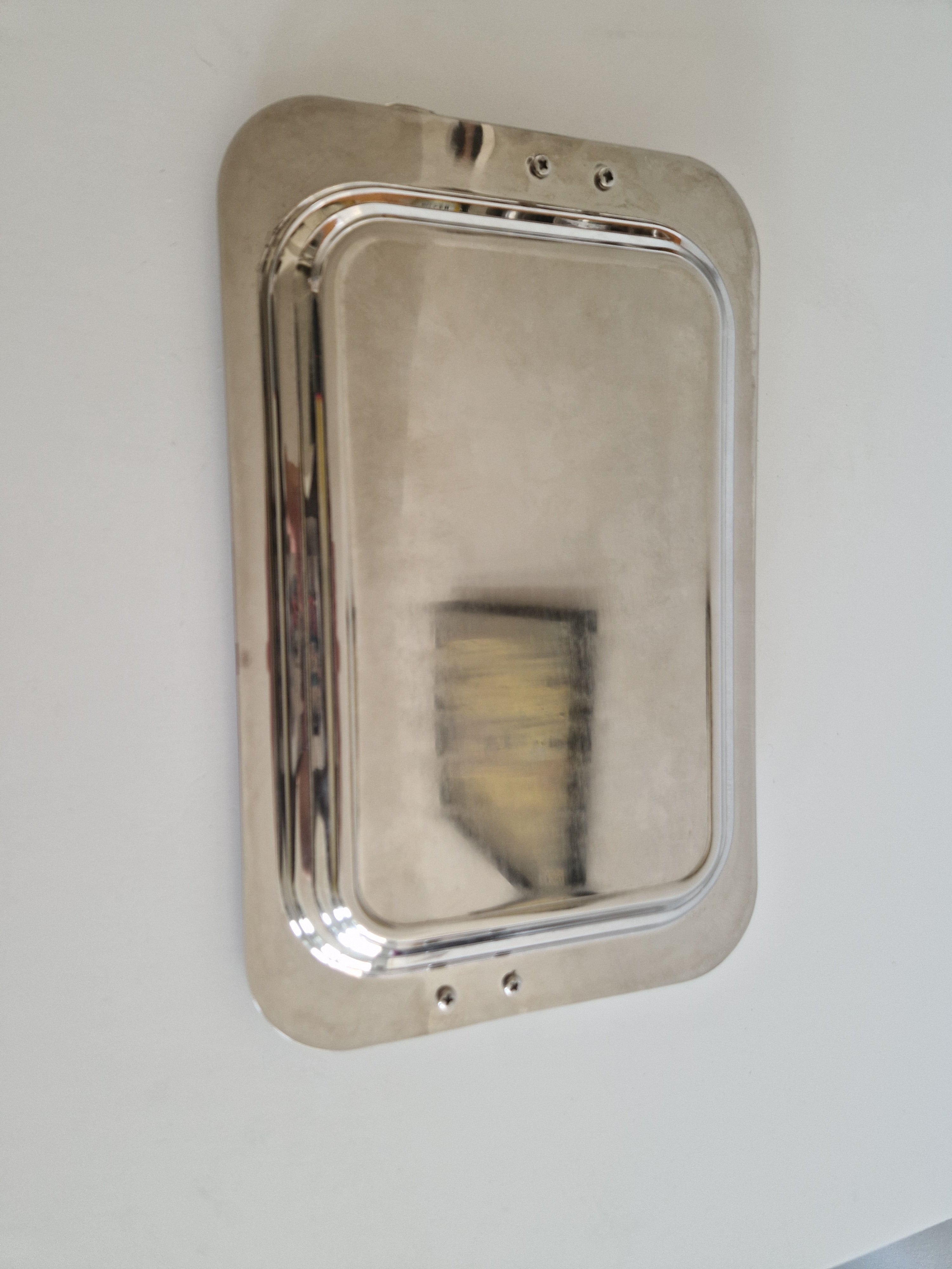 Underside of tray showing four bolt fixings securing the handles