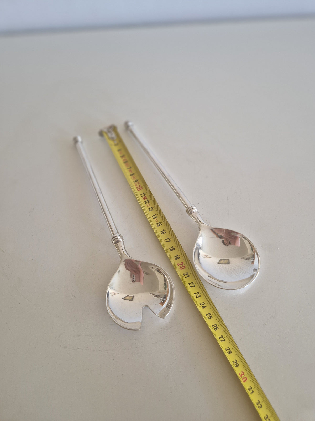 Angled view of vintage WMF 90 silver-plated salad serving spoon and fork pair