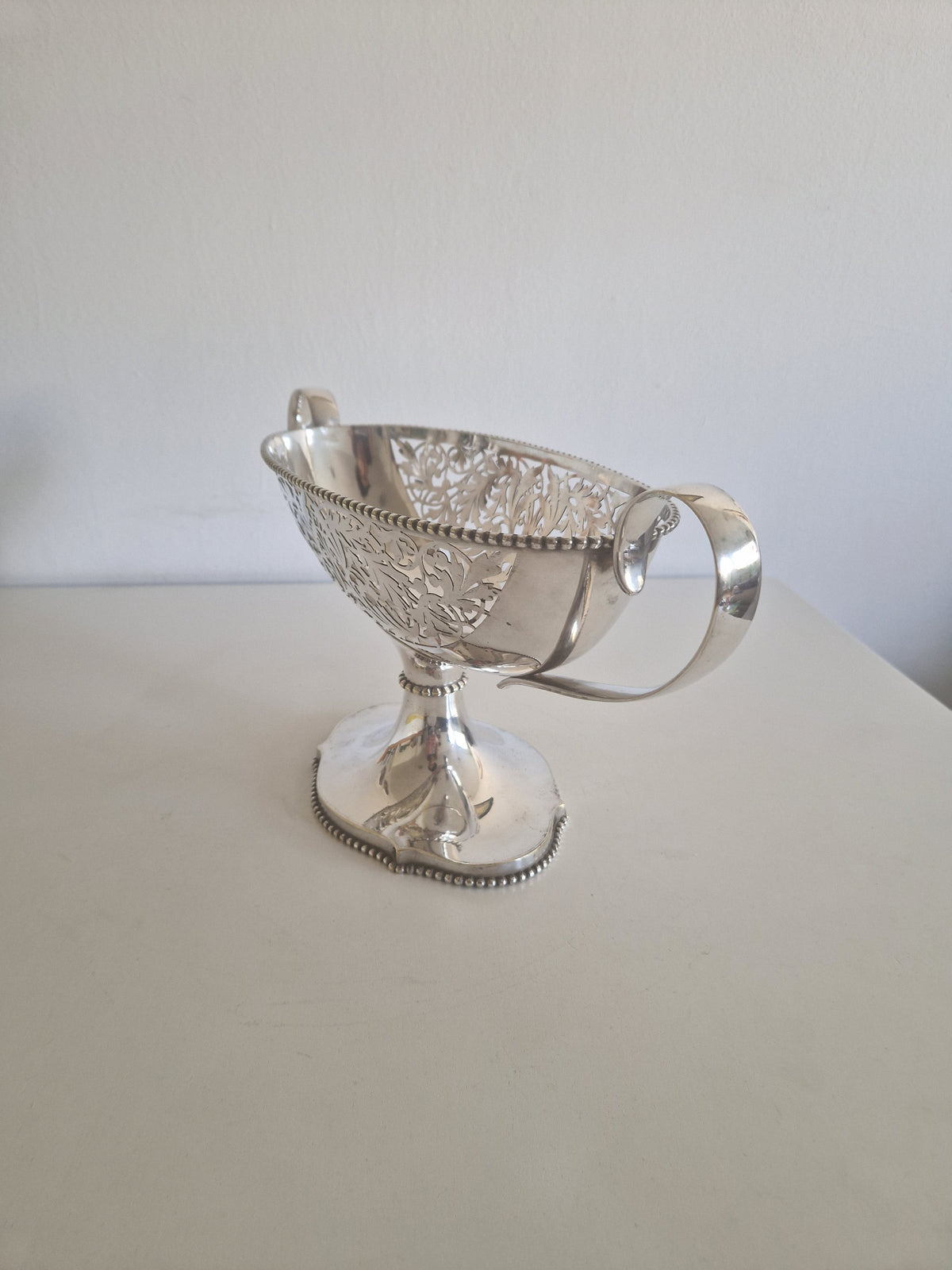 Antique silver-plated pedestal bon-bon bowl front view showing pierced reticulated acanthus wall and twin handles