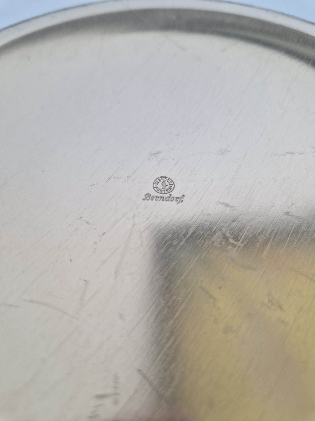 Close-up of a vintage silver platter with a Berndorf maker's mark stamp.
