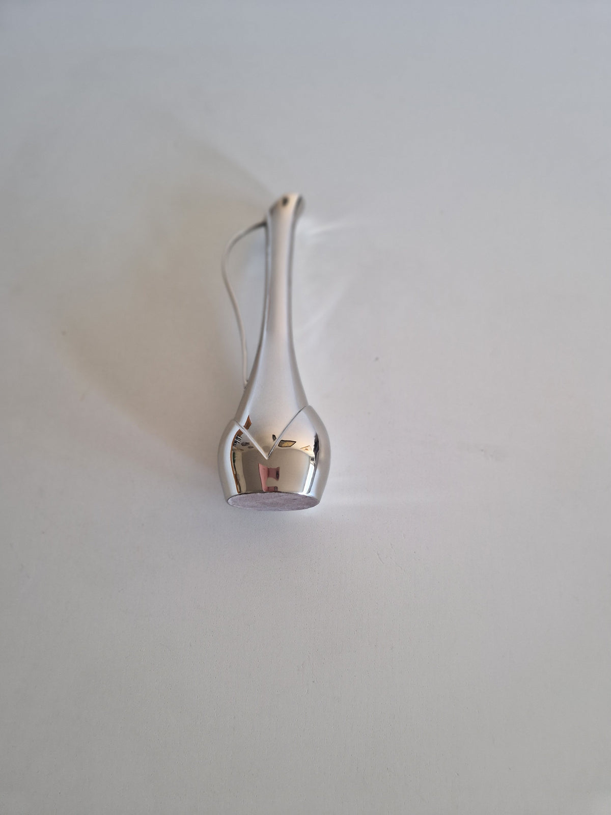 Elegant silver metallic decorative vase with a slender curved neck on a white background