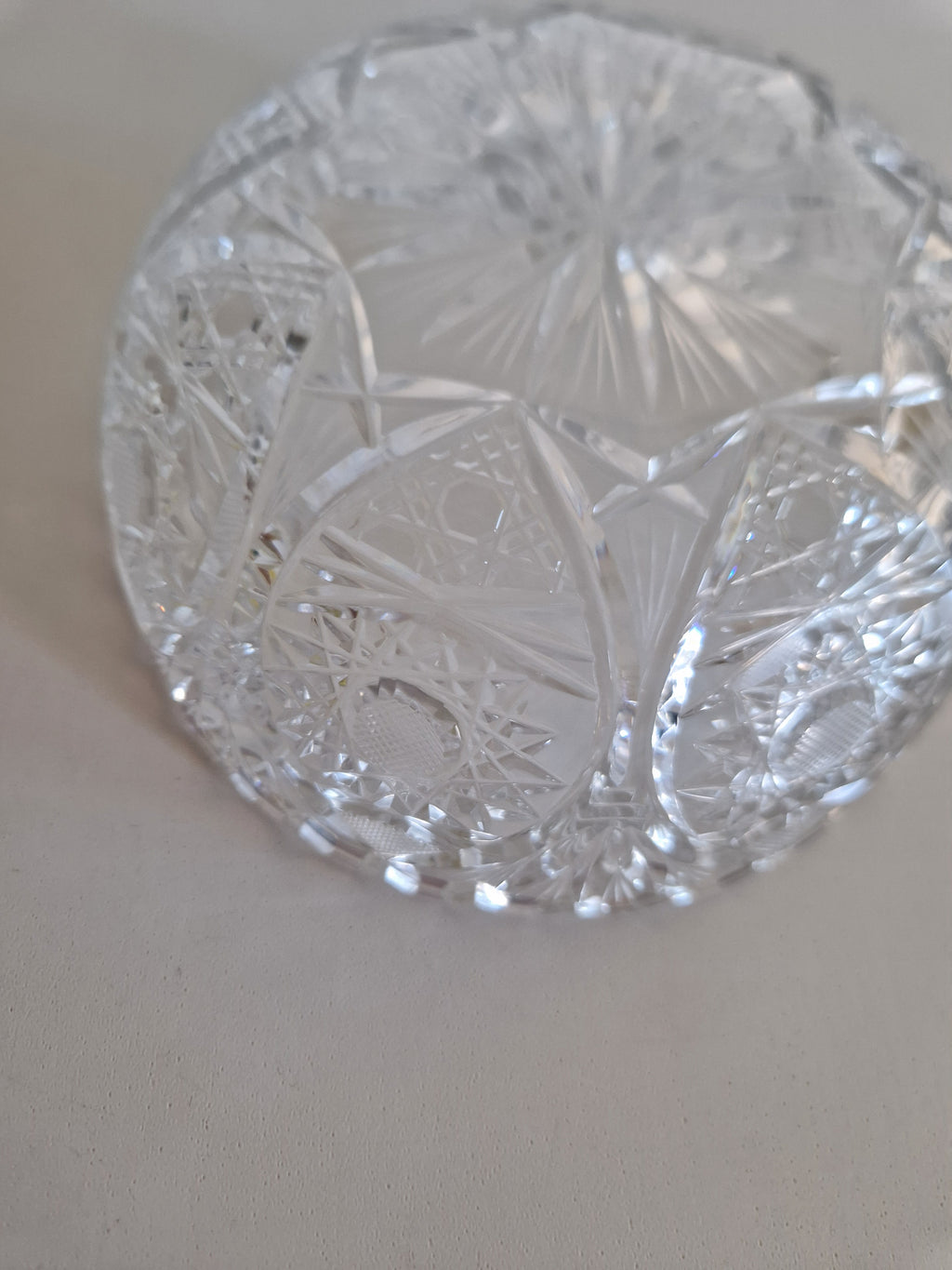 Vintage cut crystal glass bowl with intricate geometric patterns and starburst design.