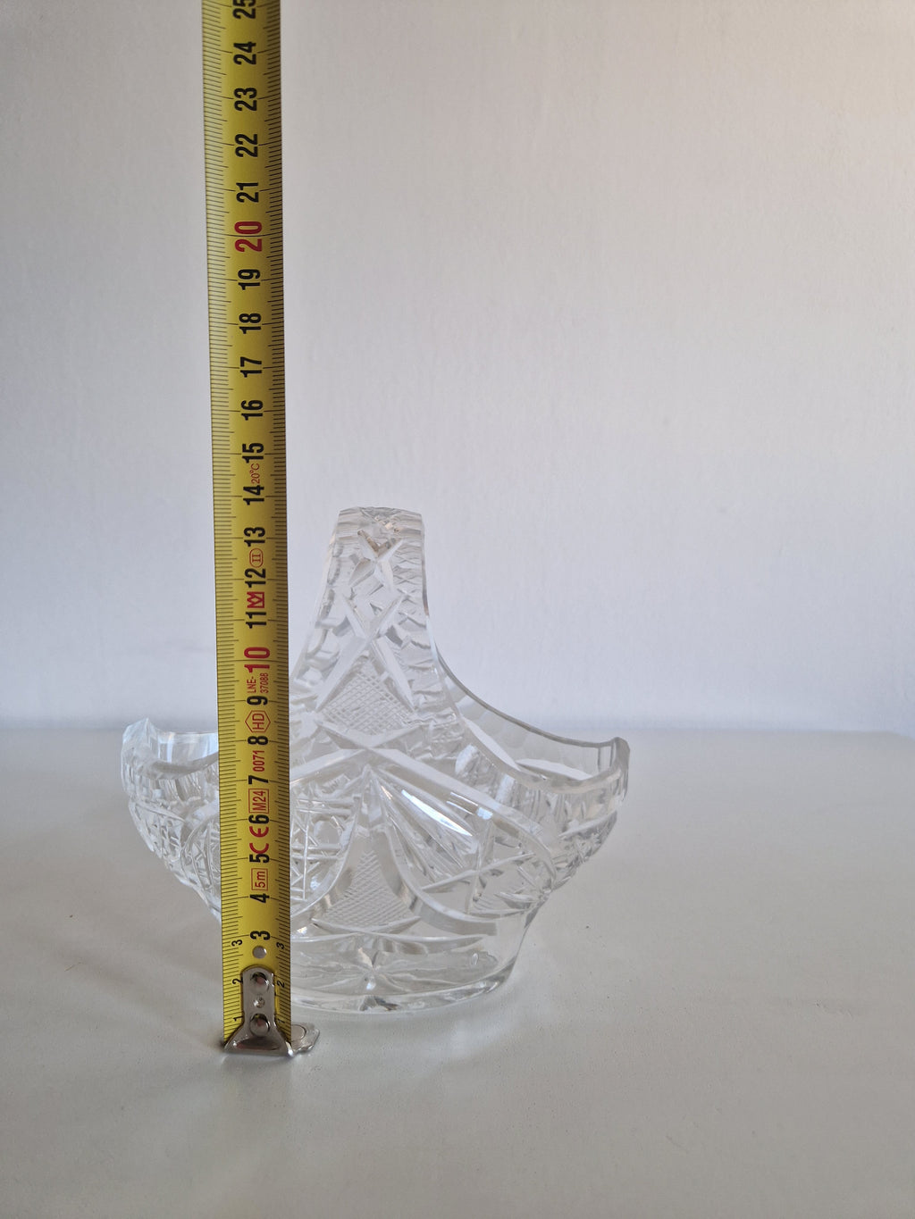 Vintage cut crystal glass bowl with a handle and measuring tape showing height