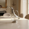 Vintage clear glass claret jug with silver-tone foot curved handle hinged lid and flared pouring spout